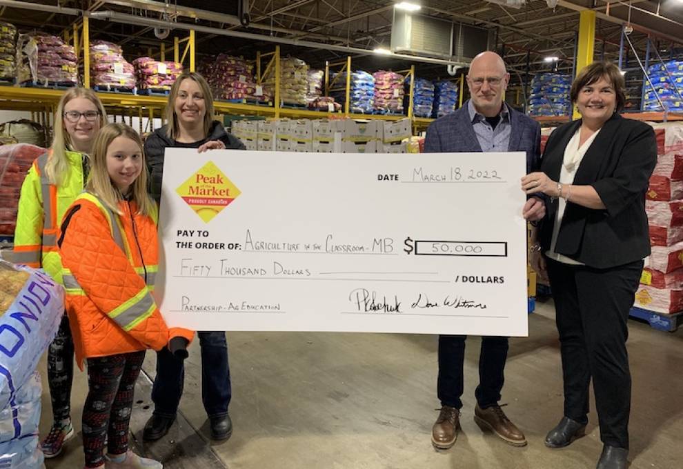 (left of cheque) CEO, Pamela Kolochuk along with her daughters Paige & Brooke and together with (right of cheque) Chair of the Board, Peter Loewen presents a $50,000 cheque on behalf of Peak of the Market to Sue Clayton, executive director, AITC-MB for the virtual resources HUB.
