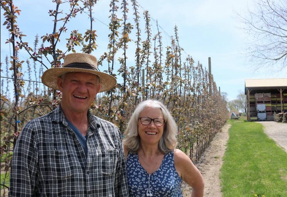 Doug Balsillie and Leslie Huffman pose in front of blooming Geneva Red cider trees in their high-density orchard, Harrow, Ontario.   
