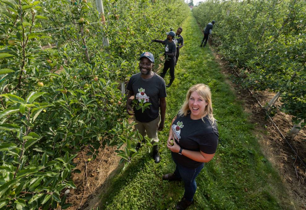 Amanda Dooney, Suncrest Orchards, is pictured with Jamaican TFW workers near Simcoe, Ontario. Photo by Glenn Lowson.
